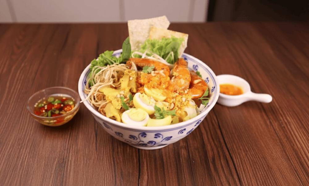 Served with herbs, banana blossom, and rice crackers, it offers a crunchy and savory experience